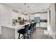 Bright kitchen featuring white cabinets, stone countertops, a kitchen island with seating, and modern light fixtures at 3197 Vittoria Ave, Henderson, NV 89044