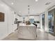 Bright kitchen featuring white cabinets, stone countertops, a kitchen island with seating, and modern light fixtures at 3197 Vittoria Ave, Henderson, NV 89044