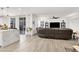 Open concept living room and kitchen featuring hardwood style floors, modern lighting, and a large sectional couch at 3197 Vittoria Ave, Henderson, NV 89044