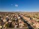 Community aerial view showcasing many homes under a blue sky with mountain views at 3448 Laguna Veneta Ave, Las Vegas, NV 89141