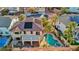An aerial view of a backyard oasis with a pool, spa, covered patio, and lush tropical landscaping at 395 Suzanne Peak Ct, Henderson, NV 89012