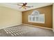 Cozy bedroom with a ceiling fan, carpeted floor, and a large bright window with shutters at 395 Suzanne Peak Ct, Henderson, NV 89012
