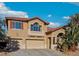 Charming two-story home with a terracotta tile roof, spacious garages, and inviting curb appeal at 395 Suzanne Peak Ct, Henderson, NV 89012