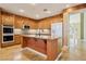 Bright kitchen featuring wood cabinetry, large center island with granite counters, and stainless appliances at 395 Suzanne Peak Ct, Henderson, NV 89012