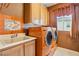 Functional laundry room with sink, tile accents, and vibrant orange washer and dryer at 395 Suzanne Peak Ct, Henderson, NV 89012