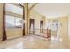 Bright living room featuring tiled floors, chandelier, staircase with wood banister, and tall windows at 395 Suzanne Peak Ct, Henderson, NV 89012