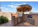 An outdoor kitchen features a built-in grill and palapa-style umbrella for shade at 395 Suzanne Peak Ct, Henderson, NV 89012