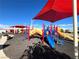 A playground is equipped with slides, climbing structures, and a shaded area for play at 395 Suzanne Peak Ct, Henderson, NV 89012