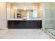 A modern bathroom featuring a double vanity, pendant lights, and a glass-enclosed shower, blending style and functionality at 3372 Dalmore St, Henderson, NV 89044