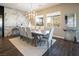 Elegant dining room with a long wooden table, comfortable seating, and expansive windows for natural light at 3372 Dalmore St, Henderson, NV 89044