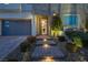 Illuminated front entrance features landscaped steps to a modern home with a three-car garage at 3372 Dalmore St, Henderson, NV 89044