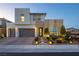 Inviting two-story home featuring a modern elevation with a well-lit landscaped front yard and brick driveway at 3372 Dalmore St, Henderson, NV 89044