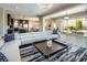 Open living room boasts a modern white couch, stylish rug, and seamless access to the kitchen and outdoor patio at 3372 Dalmore St, Henderson, NV 89044