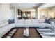 Open-concept living room and kitchen featuring a modern sectional sofa, kitchen island, and a cozy atmosphere at 3372 Dalmore St, Henderson, NV 89044
