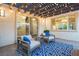 Relaxing outdoor patio with comfortable seating, string lights, and a vibrant blue rug, creating a perfect entertainment space at 3372 Dalmore St, Henderson, NV 89044