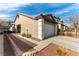 Exterior view of a home showcasing a two-car garage, neutral stucco, and low-maintenance desert landscaping at 523 Painted Cloud Pl, Las Vegas, NV 89144