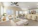 Staged living room with modern furniture, including a white sofa, glass table, and white ottomans at 523 Painted Cloud Pl, Las Vegas, NV 89144