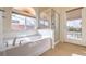 Relaxing bathroom with soaking tub, shower, and backyard access at 6412 Moss Agate Dr, Las Vegas, NV 89131
