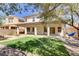 Home's rear exterior with a covered patio, an artificial lawn, and a mature shade tree at 8005 Egypt Meadows Ave, Las Vegas, NV 89178