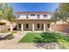 Back exterior with a covered patio, artificial lawn, and a desert-landscaped yard at 8005 Egypt Meadows Ave, Las Vegas, NV 89178