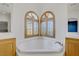 Corner bathtub surrounded by windows and wood trim at 8005 Egypt Meadows Ave, Las Vegas, NV 89178