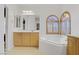 Well-lit bathroom featuring a corner tub, double sinks, and a closet at 8005 Egypt Meadows Ave, Las Vegas, NV 89178