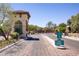 Gated community entrance featuring a guard house and well-maintained landscaping, enhancing security and curb appeal at 8005 Egypt Meadows Ave, Las Vegas, NV 89178