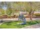 Lush front yard featuring desert landscaping, a sculpture, and mature shade trees at 8005 Egypt Meadows Ave, Las Vegas, NV 89178