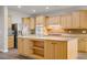 Modern kitchen with wood cabinets, stainless steel appliances, an island with sink and barstool seating at 8005 Egypt Meadows Ave, Las Vegas, NV 89178