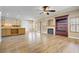 Open concept living room with fireplace and adjacent kitchen with breakfast bar at 8005 Egypt Meadows Ave, Las Vegas, NV 89178