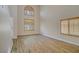 Bright living room featuring wood floors, vaulted ceiling, staircase and large window with shutters at 8005 Egypt Meadows Ave, Las Vegas, NV 89178