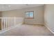 Open loft area with neutral carpet, white railings, and a window at 8005 Egypt Meadows Ave, Las Vegas, NV 89178