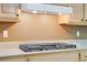 Close-up of the gas cooktop with granite countertops and wooden cabinets at 8005 Egypt Meadows Ave, Las Vegas, NV 89178