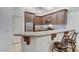 This kitchen features granite countertops, stainless steel appliances, wood cabinetry, and barstool seating at 9757 Hitching Rail Dr, Las Vegas, NV 89117