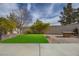 Landscaped backyard with grass, patio, and fire pit at 10658 Salmon Leap St, Las Vegas, NV 89183