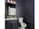 Stylish powder room with dark vanity and geometric wallpaper at 10658 Salmon Leap St, Las Vegas, NV 89183