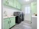 Bright laundry room, featuring stylish mint cabinets, updated washer and dryer, and ample counter space at 10658 Salmon Leap St, Las Vegas, NV 89183