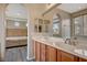 Bathroom with double vanity, large mirror, and a view into the bedroom at 11740 Via Esperanza Ave, Las Vegas, NV 89138