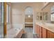 Spacious bathroom with double sinks, soaking tub, and a view of the bedroom at 11740 Via Esperanza Ave, Las Vegas, NV 89138