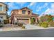 Two-story house with tan exterior, two-car garage, and landscaping at 11740 Via Esperanza Ave, Las Vegas, NV 89138