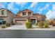 Two-story house with a tan facade and a two-car garage at 11740 Via Esperanza Ave, Las Vegas, NV 89138