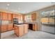 Kitchen with island, wood cabinets, and backyard access at 11740 Via Esperanza Ave, Las Vegas, NV 89138