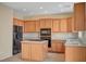 Open kitchen with island, wood cabinets, and tile floor at 11740 Via Esperanza Ave, Las Vegas, NV 89138