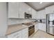 Modern kitchen with white cabinets, stainless steel appliances, and tile backsplash at 176 Kimberlite Dr, Henderson, NV 89011