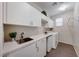 Modern laundry room with white cabinets and a built-in sink at 176 Kimberlite Dr, Henderson, NV 89011