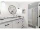 Modern bathroom with white cabinets, gray counters, and a white subway tile shower at 1901 Summer Pine Ct # 101, Las Vegas, NV 89134