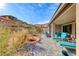 Landscaped backyard featuring desert plants, stone features, and a covered patio with comfortable seating at 29 Sun Mirage Ave, Henderson, NV 89011