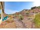 Desert-style backyard with rock features, native plants, and inviting patio seating area at 29 Sun Mirage Ave, Henderson, NV 89011