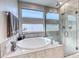 Elegant bathroom featuring an oval soaking tub and a glass enclosed shower with tile surround at 29 Sun Mirage Ave, Henderson, NV 89011