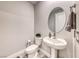 Cozy powder room with a pedestal sink, oval mirror, and updated fixtures at 29 Sun Mirage Ave, Henderson, NV 89011